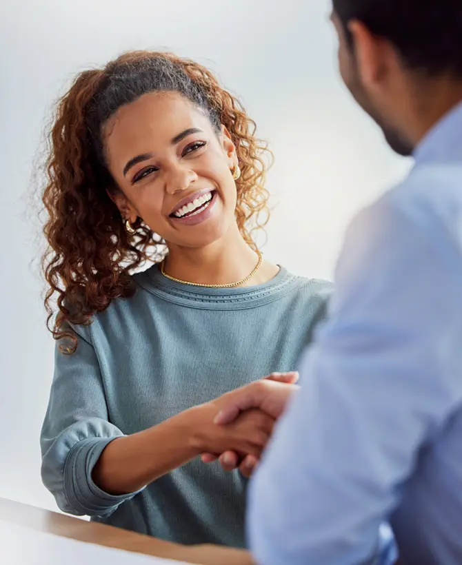 1 femme qui serre la main à 1 homme